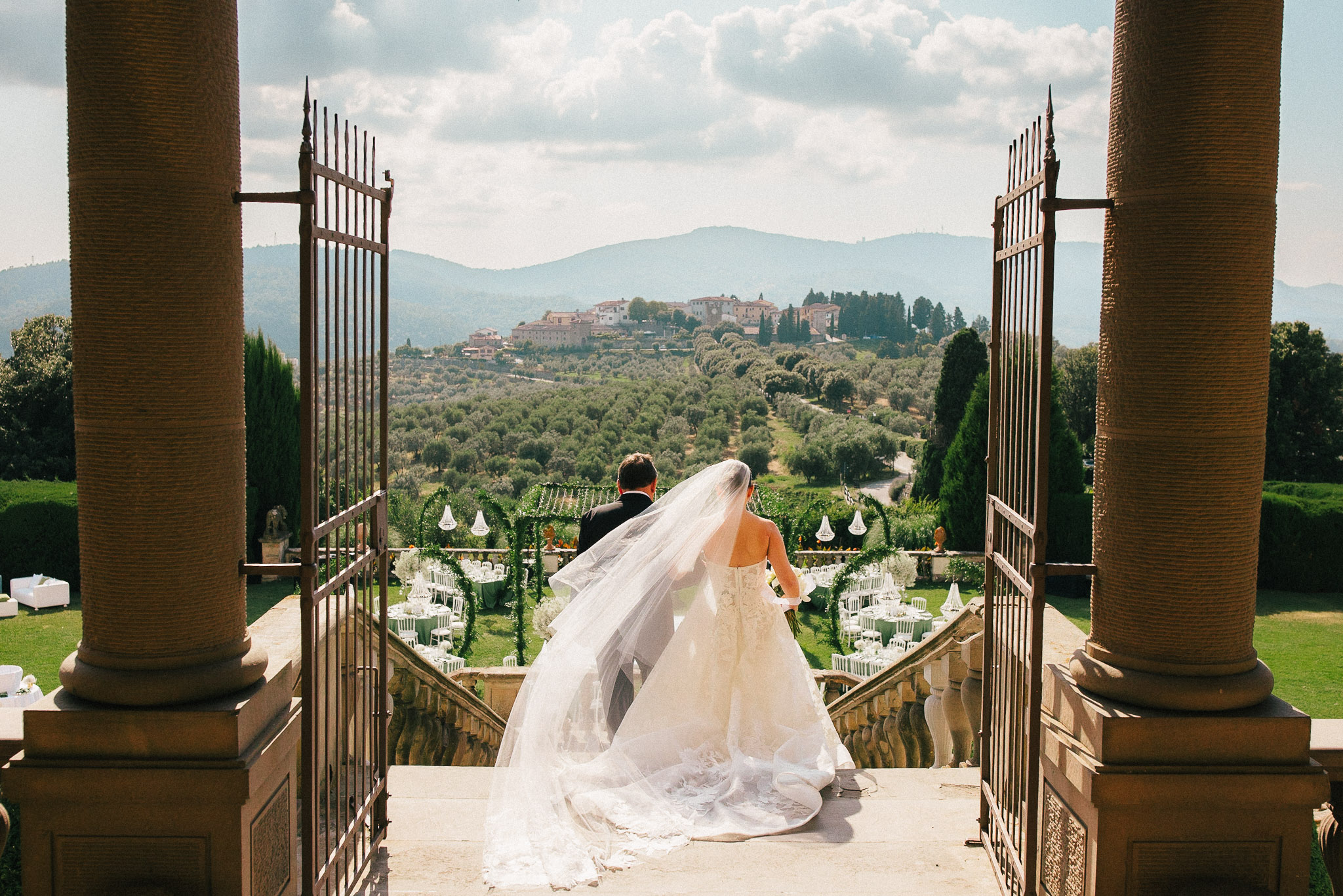 Bride and groom entering an Italian wedding terrace with a countryside view