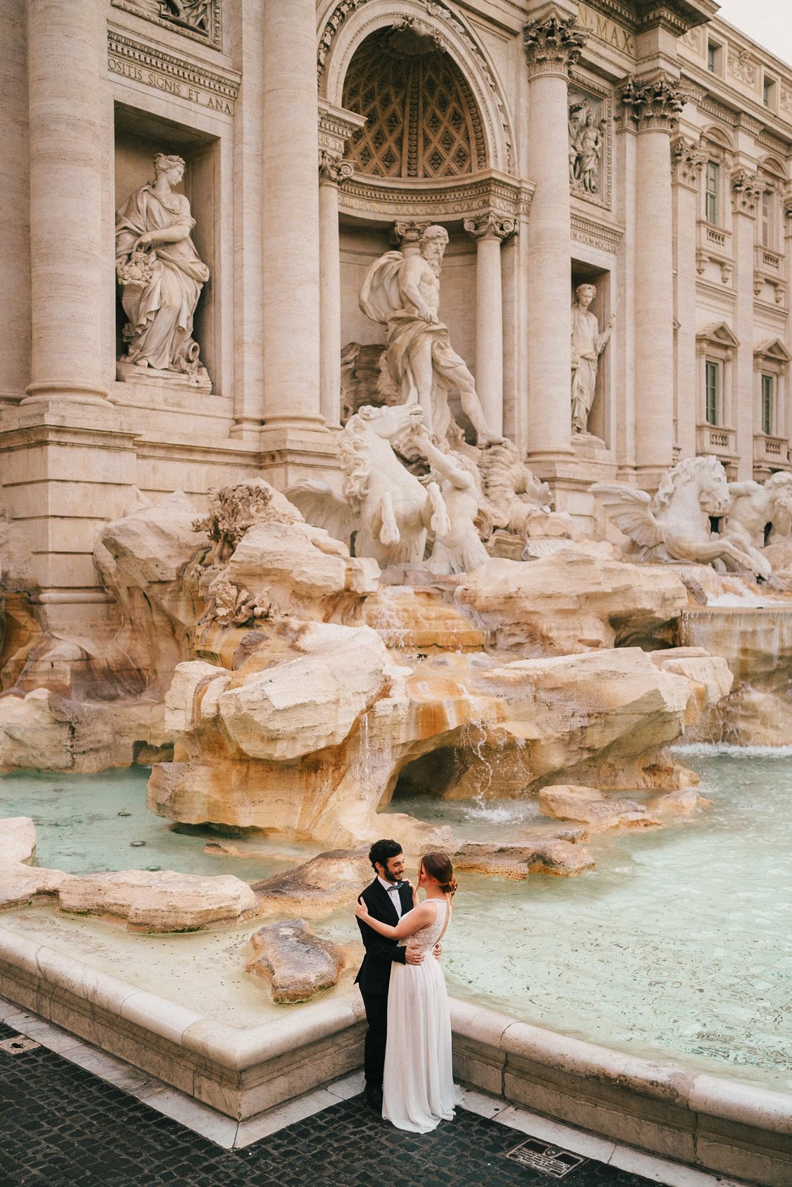 Bride standing in front of an ornate Italian fountain