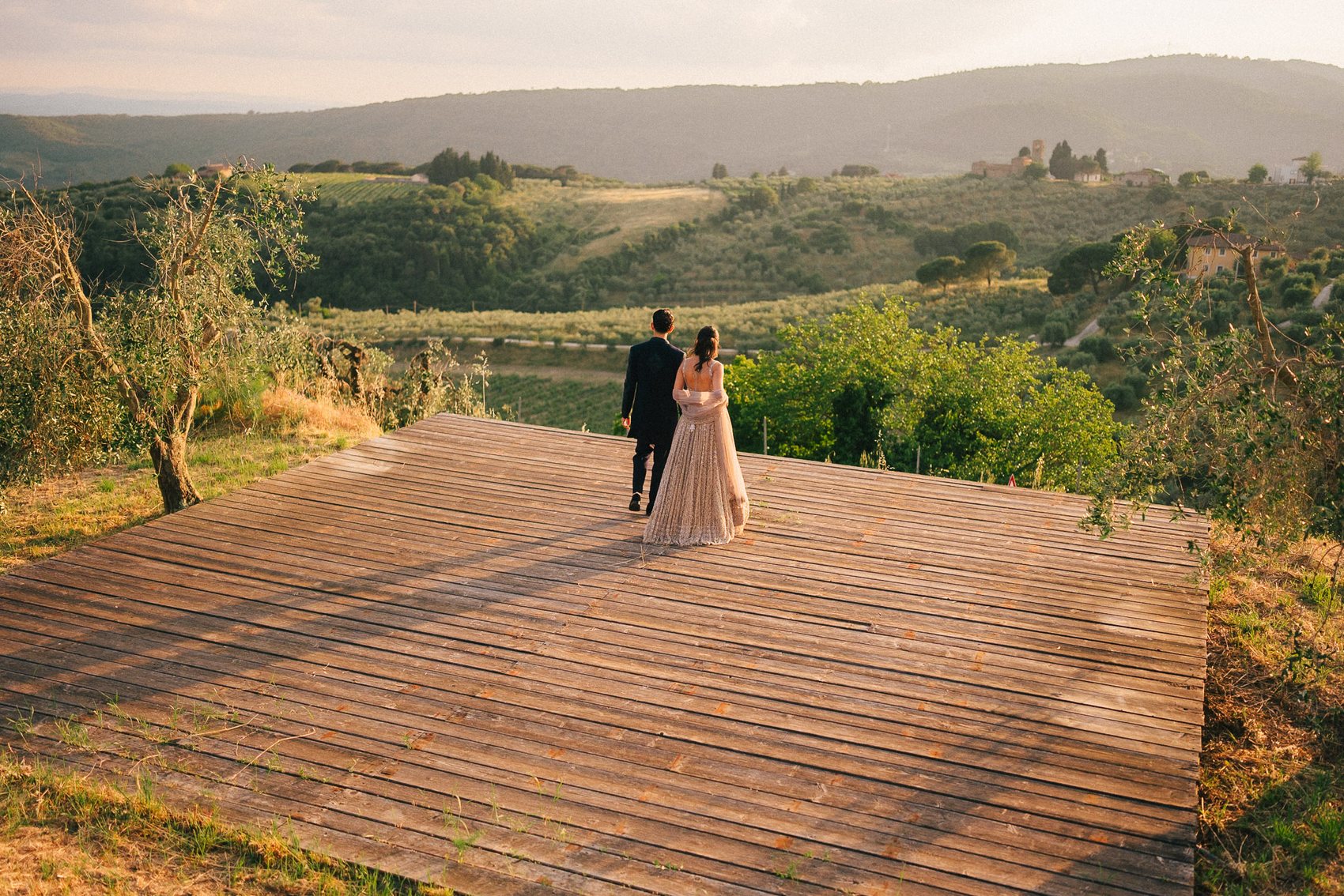 Couple walking across an Italian villa terrace at sunset